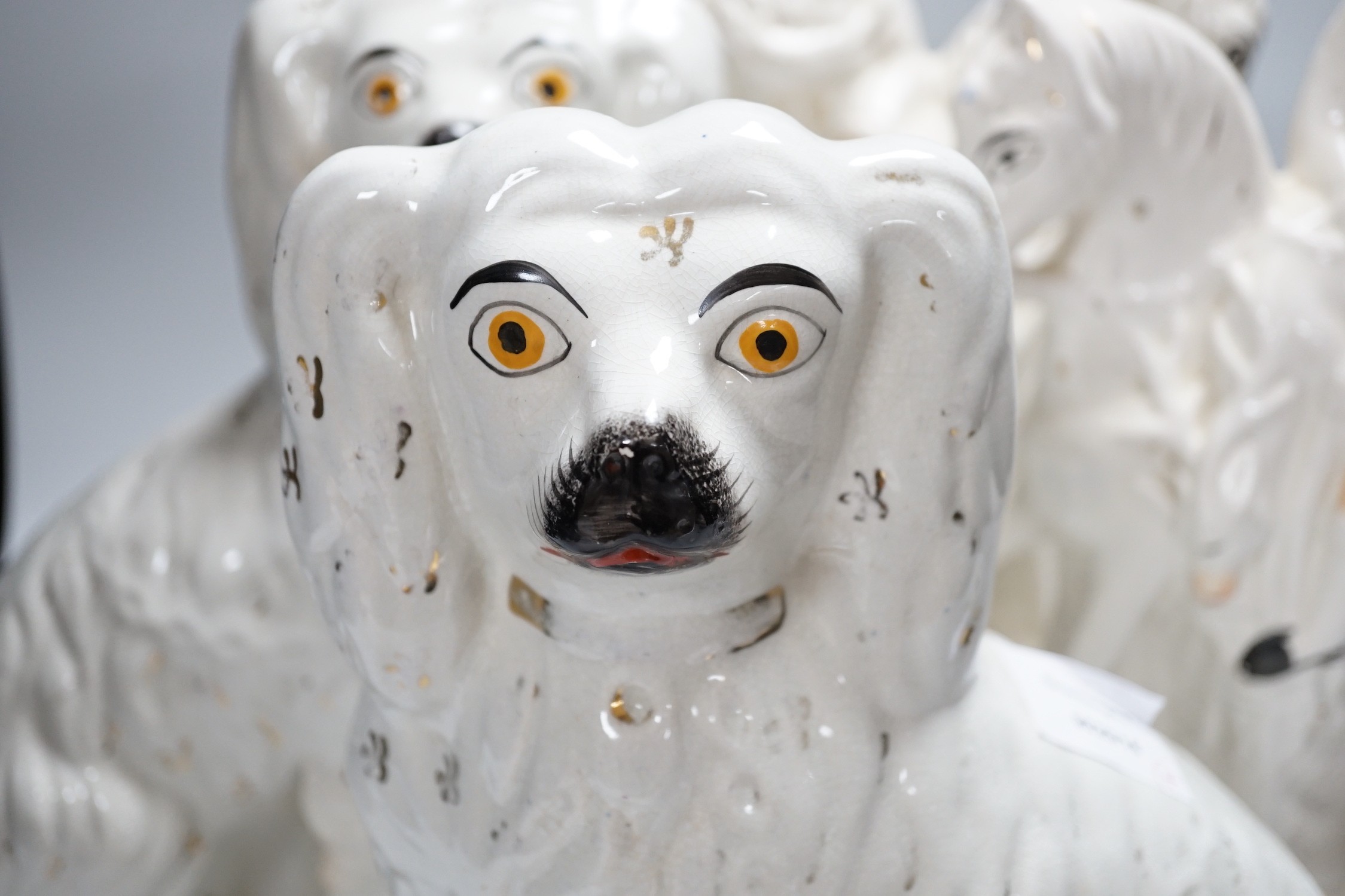 A pair of Staffordshire pottery spaniels, 30cm high, and a pair of equestrian groups, 19th century